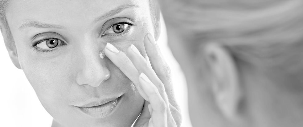 Woman applying concealing cream on her nose