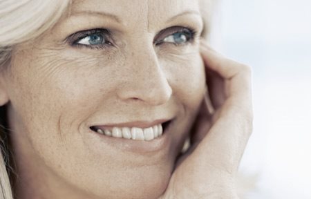 Ženska v srednjih letih se smehlja.